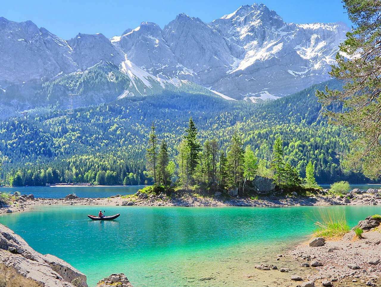 Ruderboot auf dem türkisfarbenen Eibsee. Im Hintergrund die Zugspitze