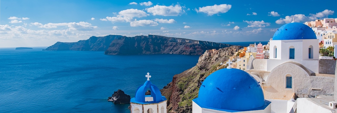 Blick von Santorini von Kirche mit blauem Dach auf das Meer hinaus
