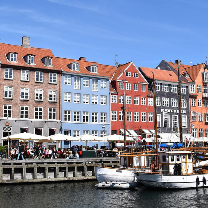 Blick auf Nyhavn mit einem Schiff und Restaurantsterrassen Kopenhagen Dänemark buchbar bei Olivers Touristik World