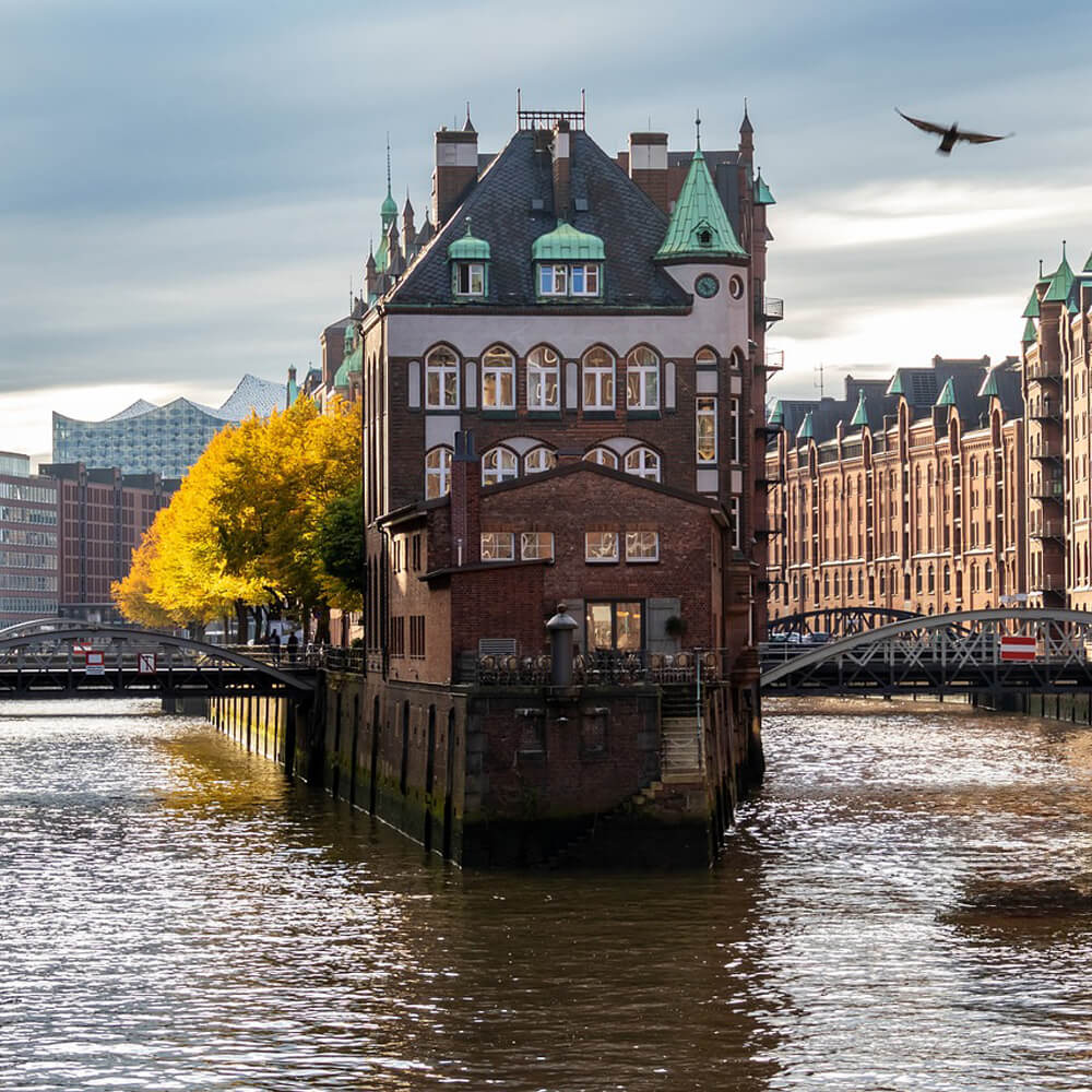 Blickauf die Speicherstadt in Hamburg. Ein Backsteinhaus zwischen 2 Kanälenn