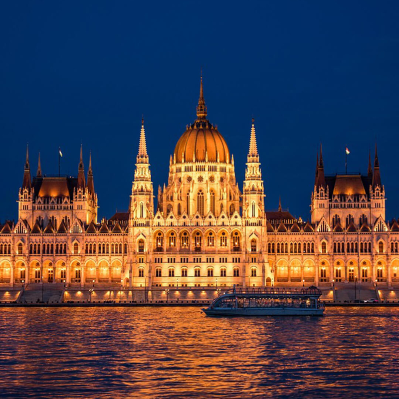 Blick auf dasParlamentsgebäude am Ufer der Donau beleuchtet am Abend buchbar bei Olivers Touristik World
