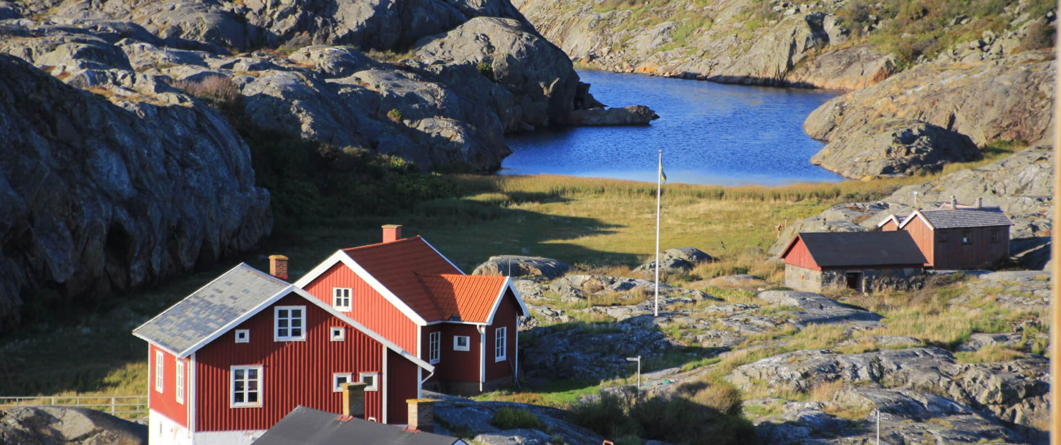 Blick auf typische rote Schweden Haeuser in einem Flord Blick auf typische rote Schweden Häuser in einem Fjord