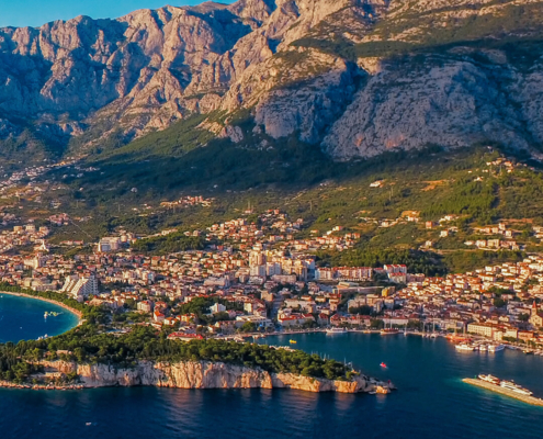 Blick über das Meer auf Makarska und die Berge des Biokovo-Gebirges an der Makarska Riviera in Kroatien