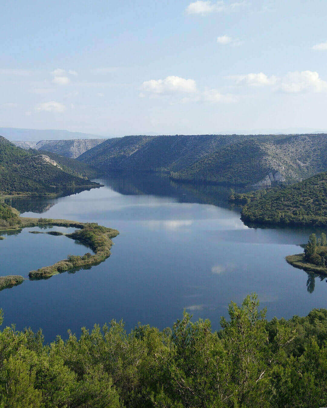 Blick auf den Fluss Krka und die umliegenden Berge im Krka Nationalpark in Kroatien Blick auf den Fluss Krka und die umliegenden Berge im Krka Nationalpark in Kroatien