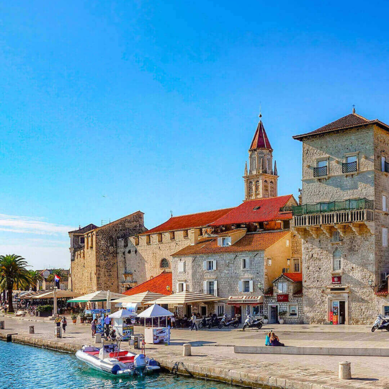 Die Strandpromenade von Trogir vom Meer mit ihren historischen Häusern. Strandpromenade