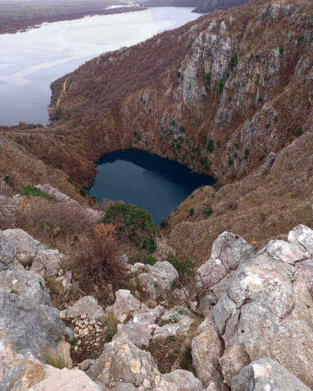 Blick auf den roten See umgeben von den steilen Karstwänden in Imotski in Kroatien Blick auf den roten See umgeben von den steilen Karstwänden in Imotski in Kroatien